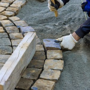 laying-granite-cubes-stone-pavement-city-street-with-construction-worker-min